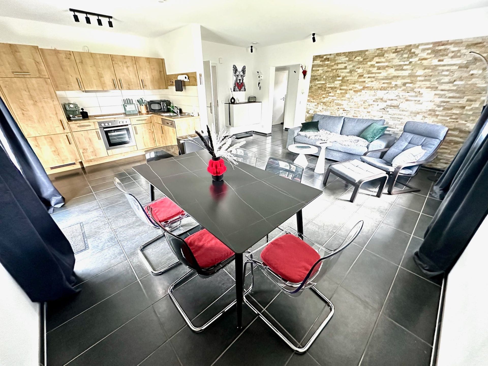 Offener, großzügiger Wohn- und Essbereich mit integrierter Küche und Steinwand in der Ferienwohnung in Feldberg