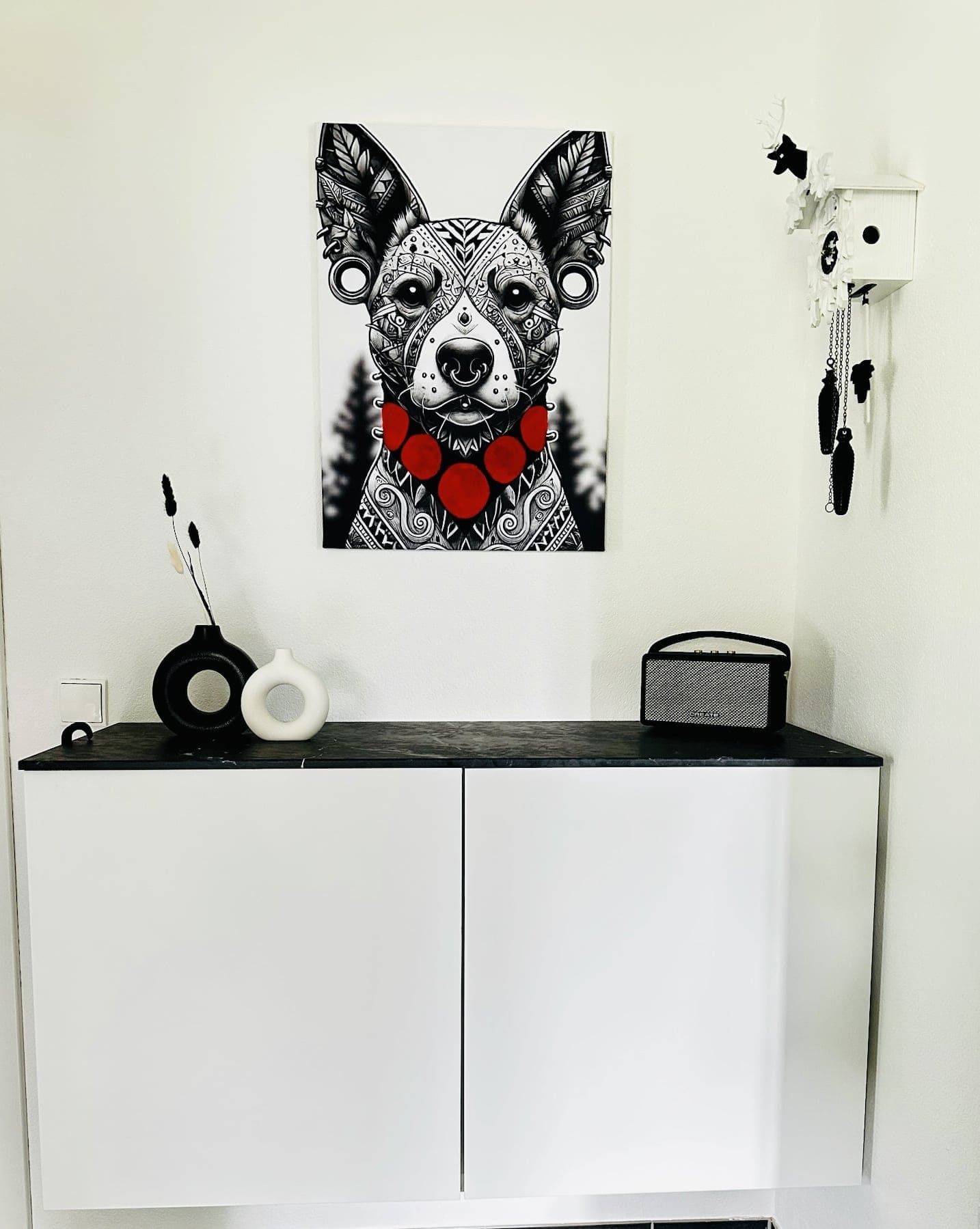 Stilvolle Einrichtung im Wohnbereich der Ferienwohnung in Feldberg mit moderner Kunst und Kuckucksuhr