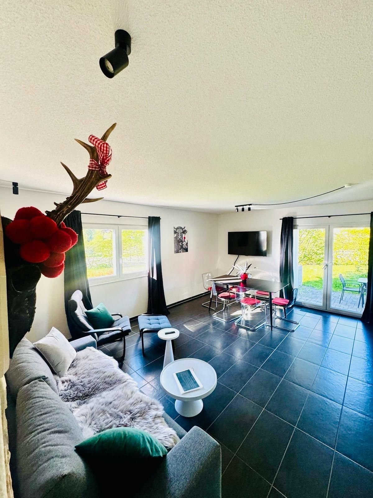Helles Wohnzimmer der Ferienwohnung in Feldberg mit traditioneller Schwarzwald-Dekoration und direktem Zugang zur Terrasse