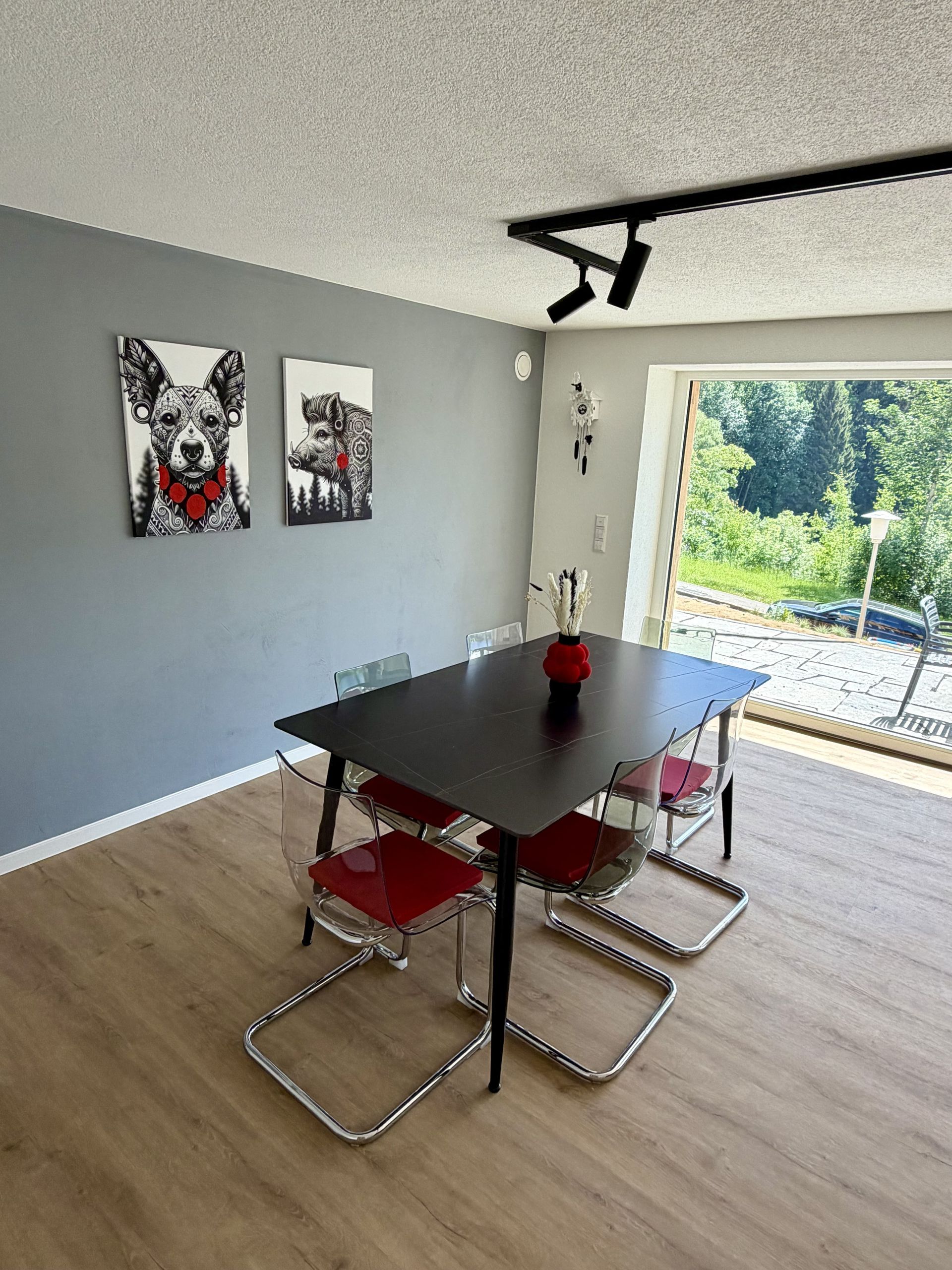Heller Essbereich mit Schwarzwald-Kunstmotiven und Zugang zur Terrasse in der Ferienwohnung in Triberg