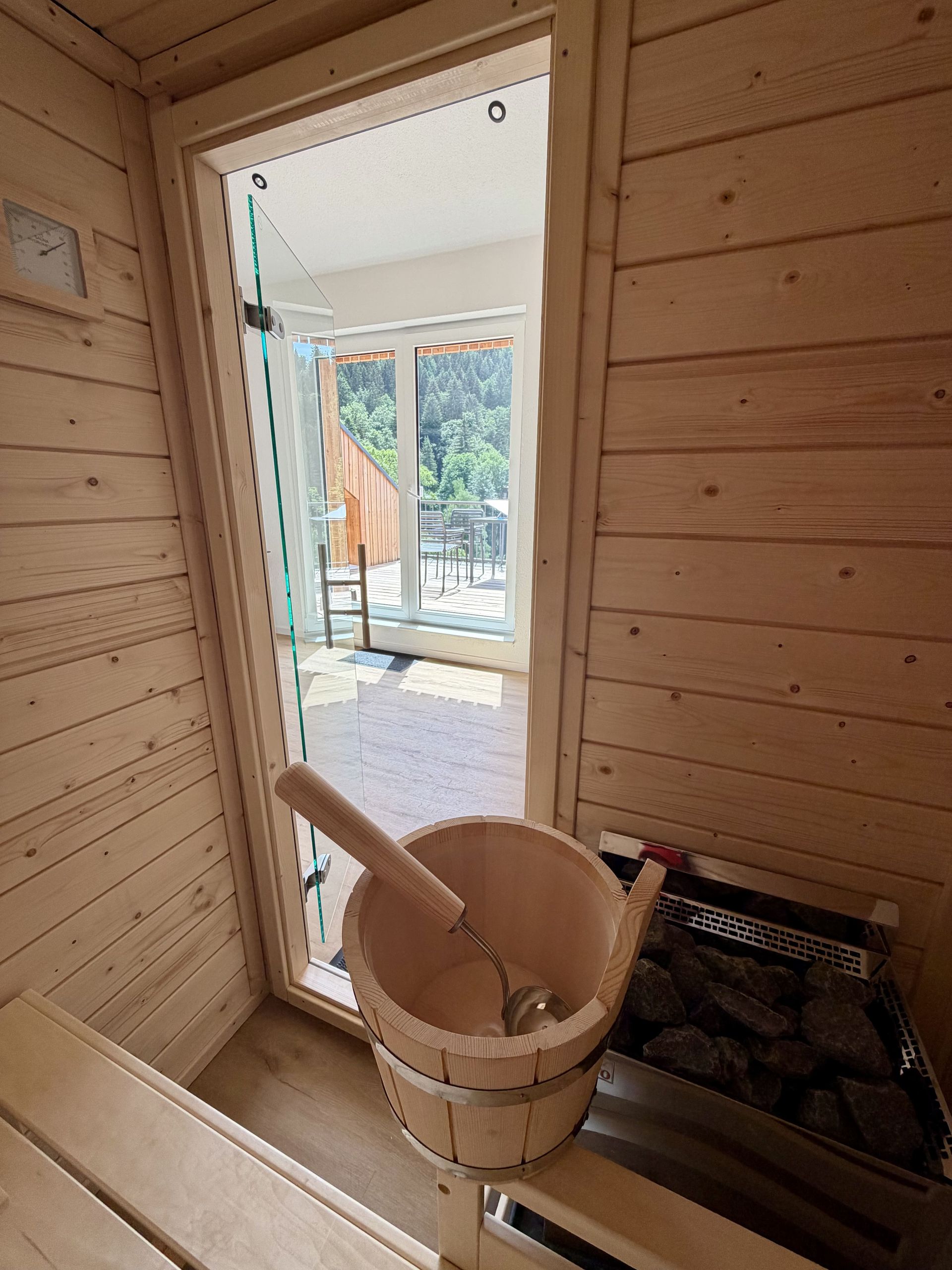 Blick aus der privaten Sauna durch die Glastür auf den sonnigen Balkon der Ferienwohnung in Triberg