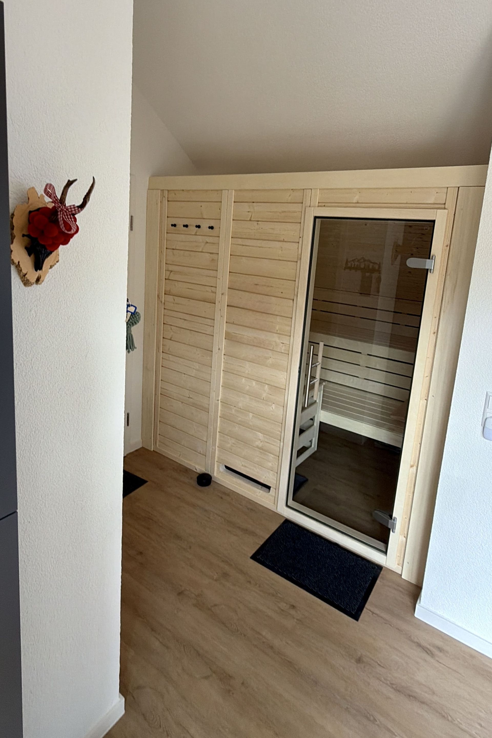 Private Holz-Sauna mit Glastür und traditioneller Schwarzwald-Dekoration im Innenbereich der Ferienwohnung in Triberg