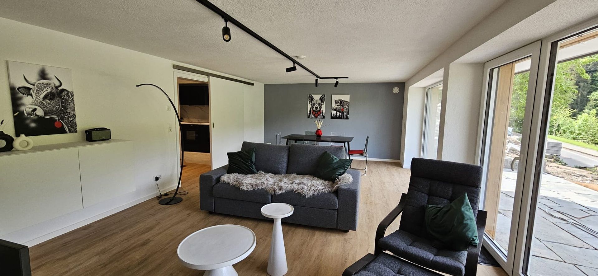 Offenes Wohnzimmer der Ferienwohnung in Triberg mit gemütlichem Sofa und großen Fensterfronten