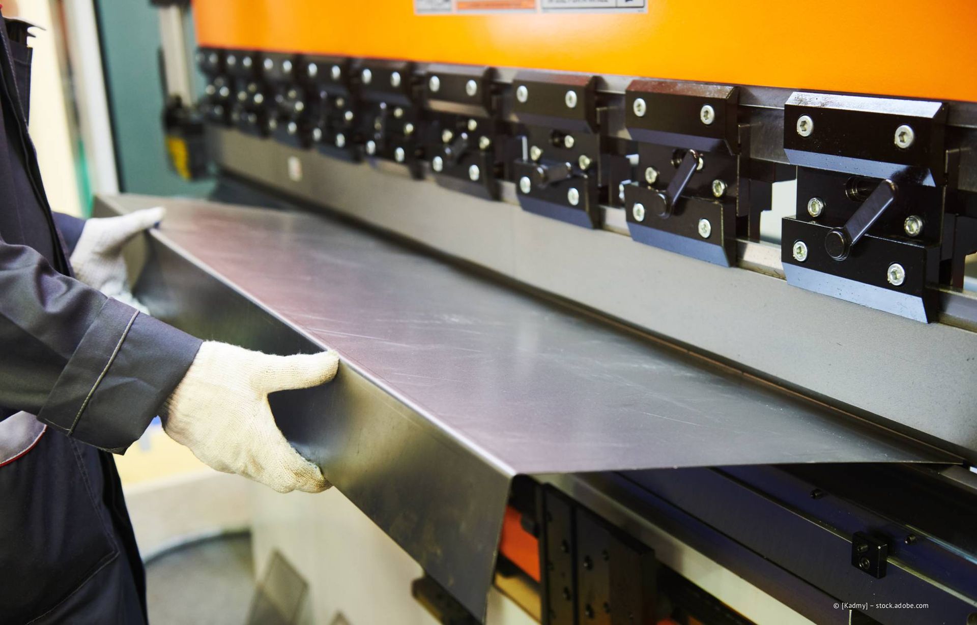 Außentreppe aus Metall an einem Backsteingebäude. Graues Geländer, mehrere Ebenen, bedeckter Himmel.