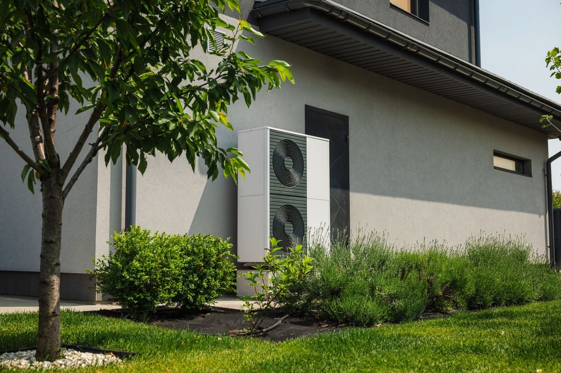 Extérieur d'une maison avec un bloc extérieur de climatisation.