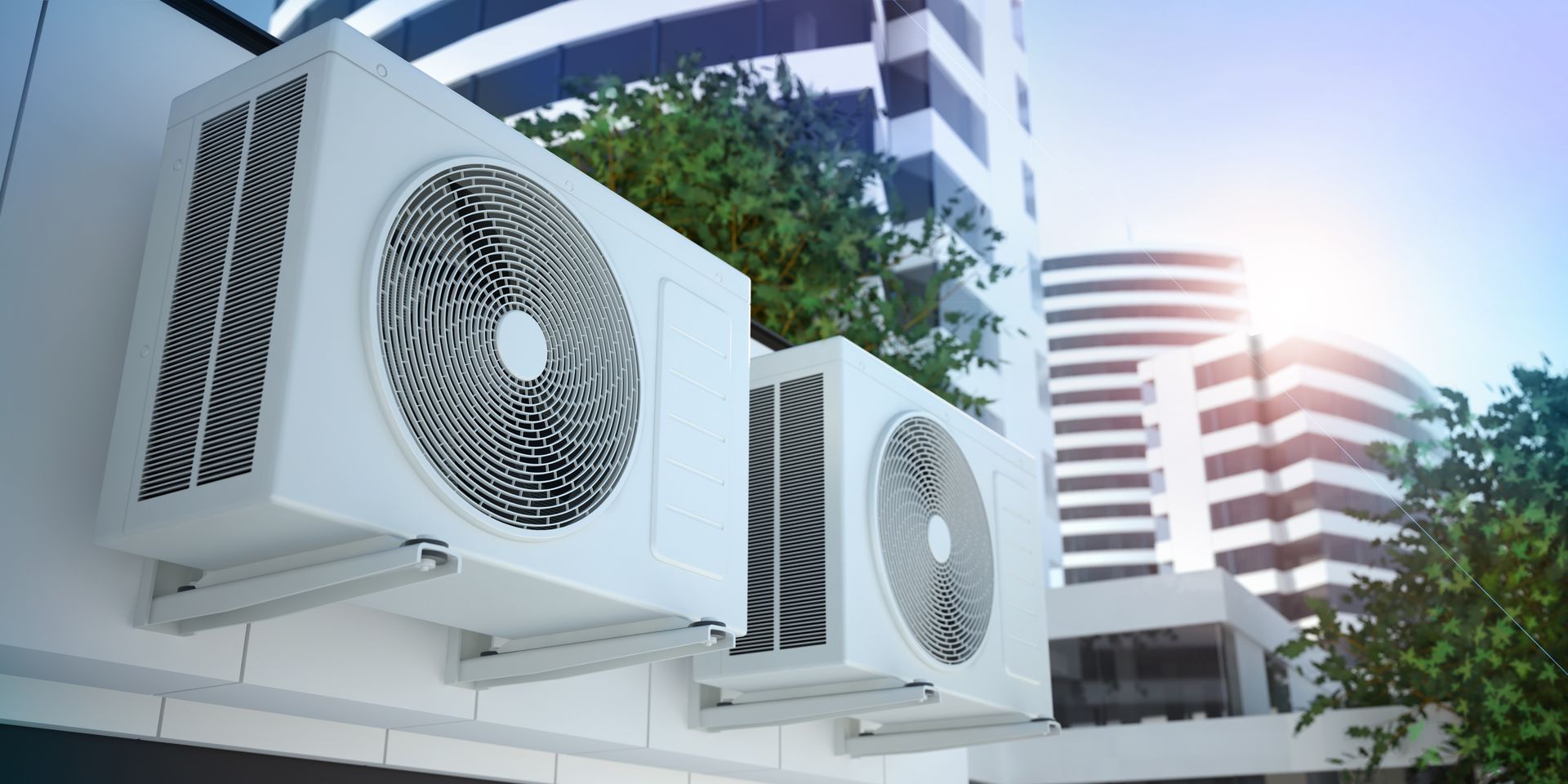 Une rangée de climatiseurs extérieurs près d'immeubles de bureaux modernes.