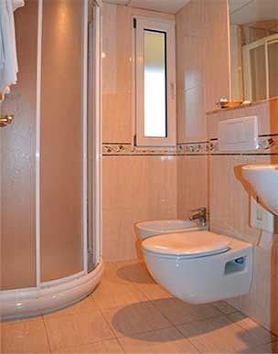 Un baño con inodoro, lavabo, ducha y bidet.