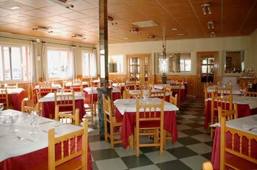 Un restaurante con mesas y sillas y suelo de cuadros.