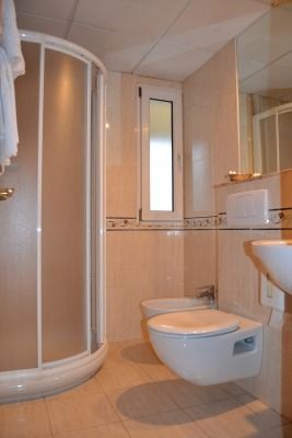 Un baño con inodoro, lavabo y ducha.