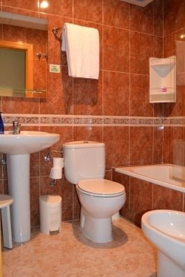 Un baño con inodoro, lavabo y bañera.