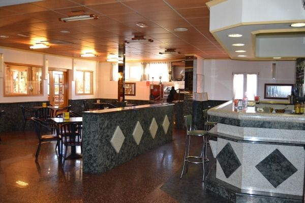 Un restaurante con mesas y sillas y un bar.