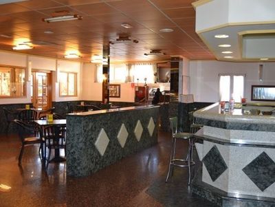 Un restaurante con mesas y sillas y un bar.