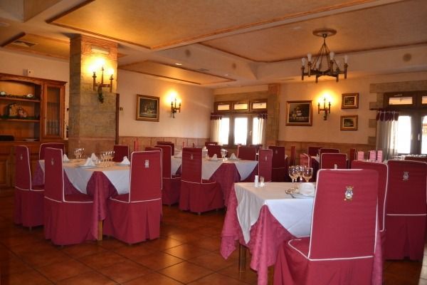 Un comedor con mesas y sillas y una lámpara de araña.