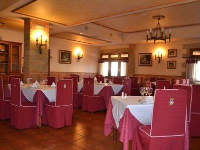 Un comedor con mesas y sillas y una lámpara de araña.