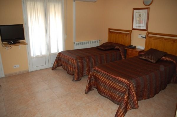 Un dormitorio con dos camas y un televisor de pantalla plana.