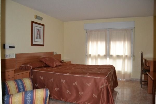 Una habitación de hotel con una cama grande y una silla.