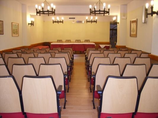 Filas de sillas en un auditorio con una mesa al fondo