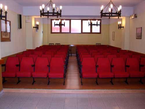 Filas de sillas rojas están alineadas en un auditorio