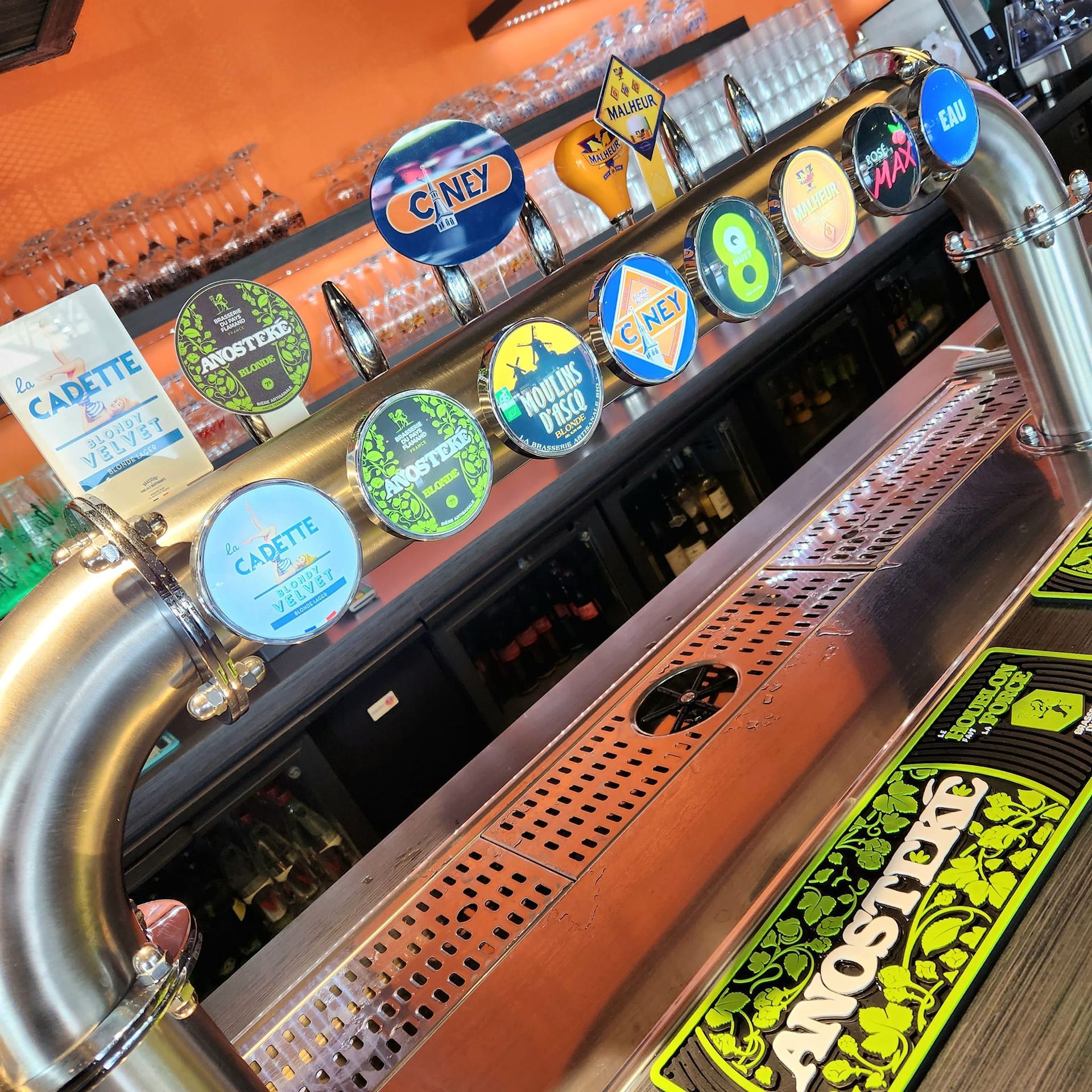 Un bar à bières pression avec des étiquettes de bières variées.