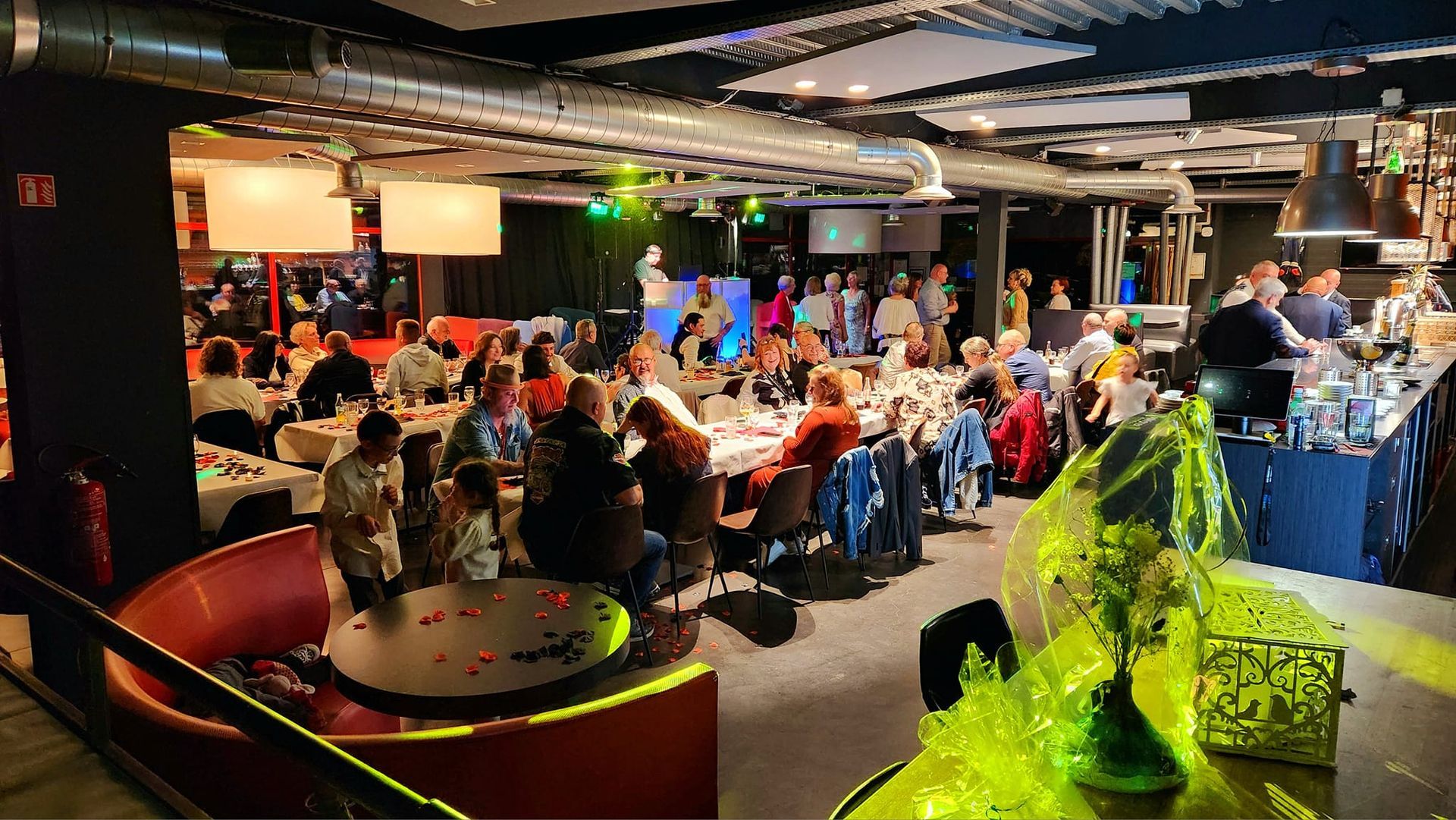 Intérieur de la brasserie privatisée pour une célébration de mariage. Grand groupe assis à table.
