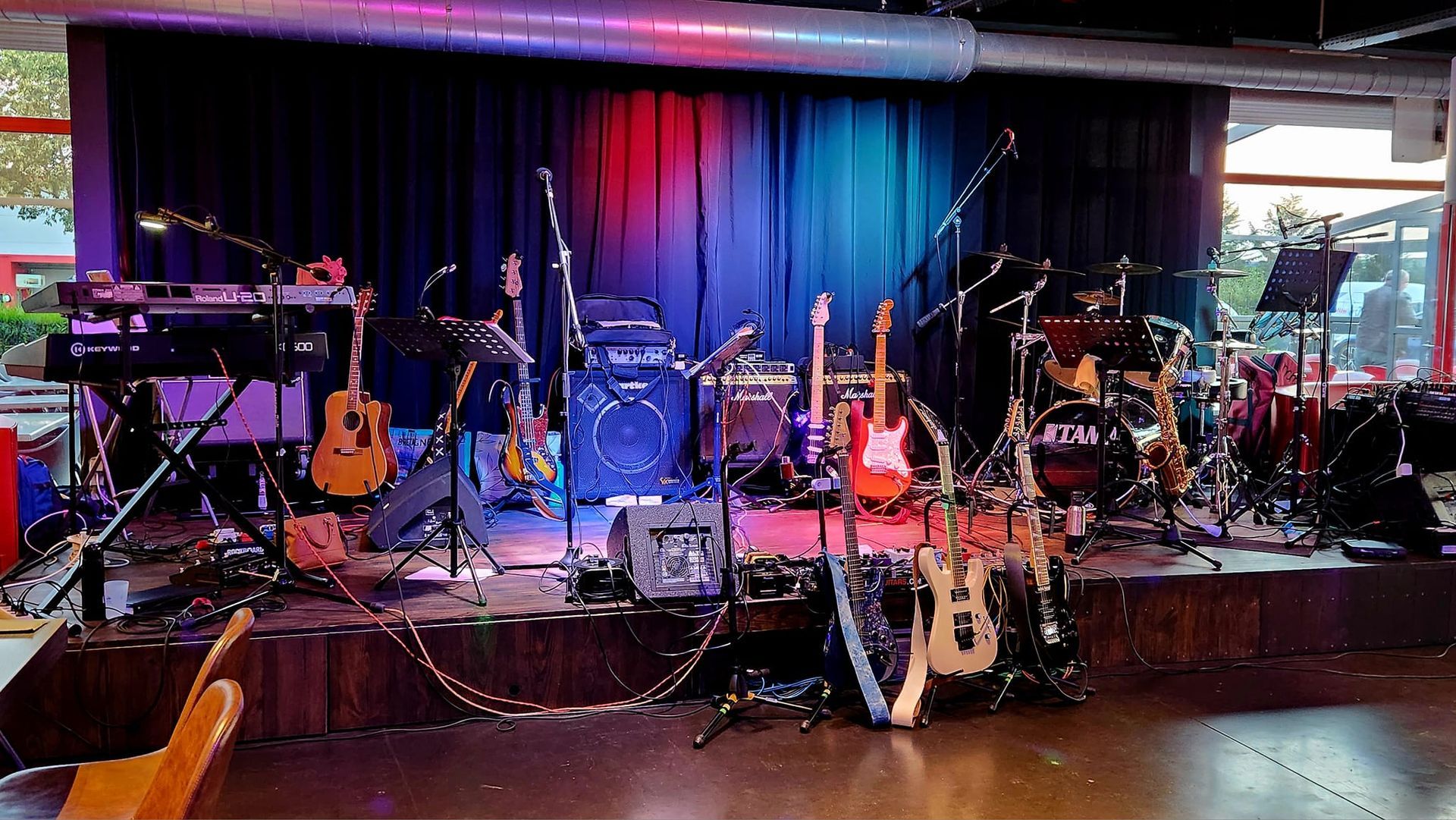 Instruments du groupe sur scène : guitares, batterie, clavier, amplificateurs et microphones.