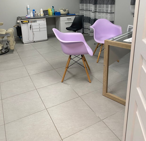 Salle avec deux chaises lavande. Armoires blanches et comptoir en arrière-plan.