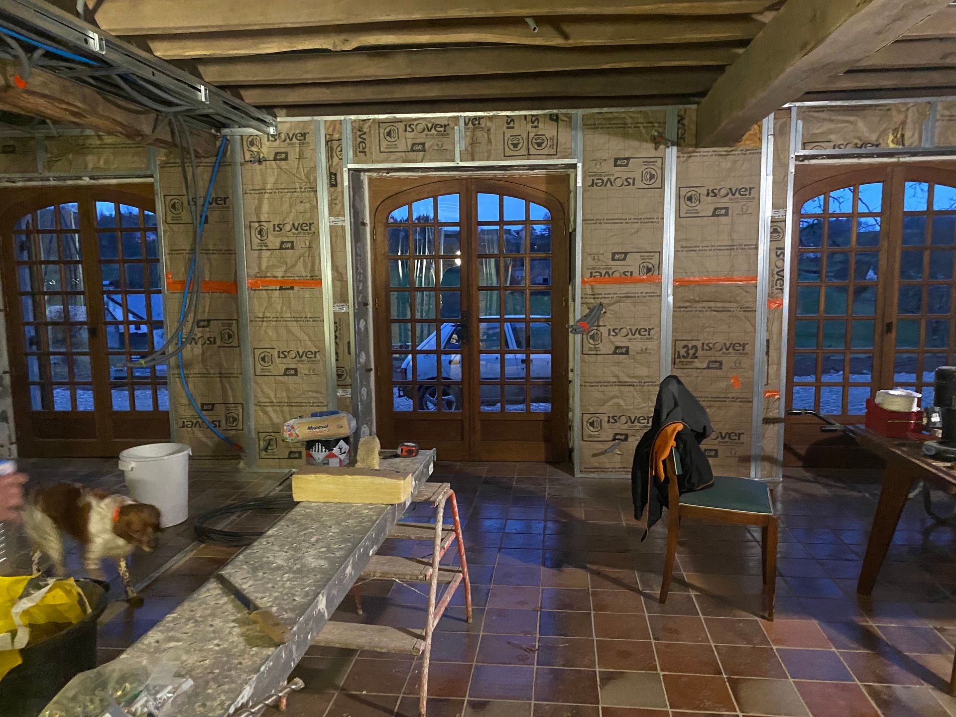 Aménagement intérieur avec isolation, charpente métallique, portes cintrées.