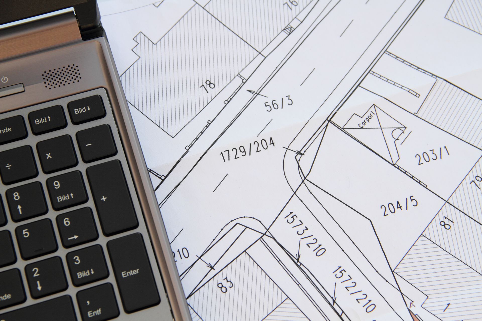 Calculatrice posée sur des plans architecturaux comportant des mesures et des annotations dessinées à la main