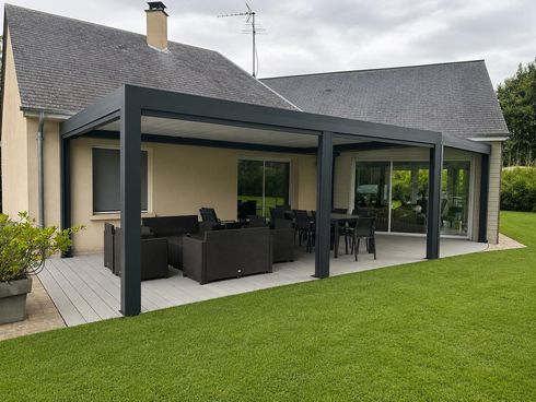 Pergola bioclimatique attenante à une maison avec salon de jardin et espace repas sur la terrasse