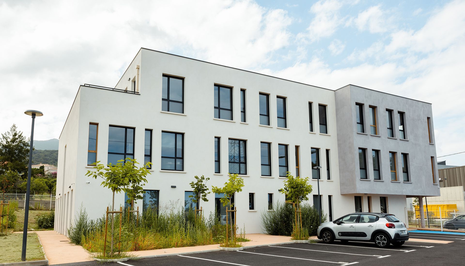 Bâtiment blanc de trois étages avec de nombreuses fenêtres.