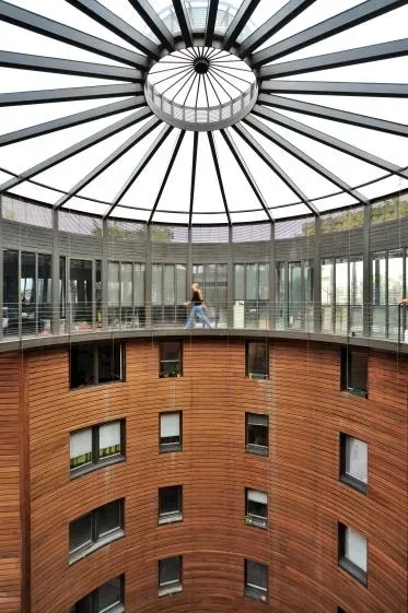 Une personne marche sur un balcon circulaire sous un dôme de verre.