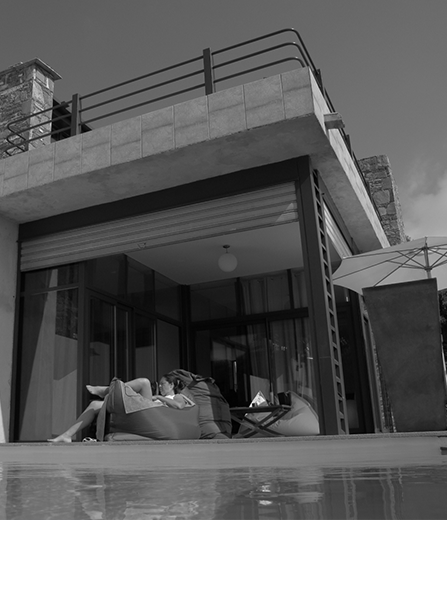 Une personne se détendant sur un pouf sur la terrasse d'une maison moderne.