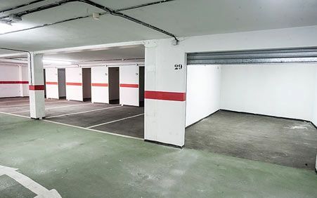 Un estacionamiento con piso verde y rayas rojas y blancas en las paredes.