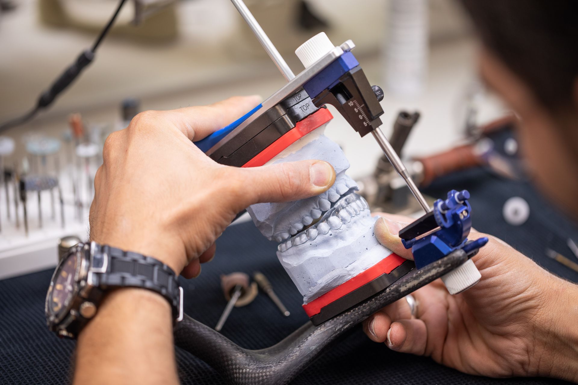 Ein Zahntechniker arbeitet an einem Modell eines Zahns.