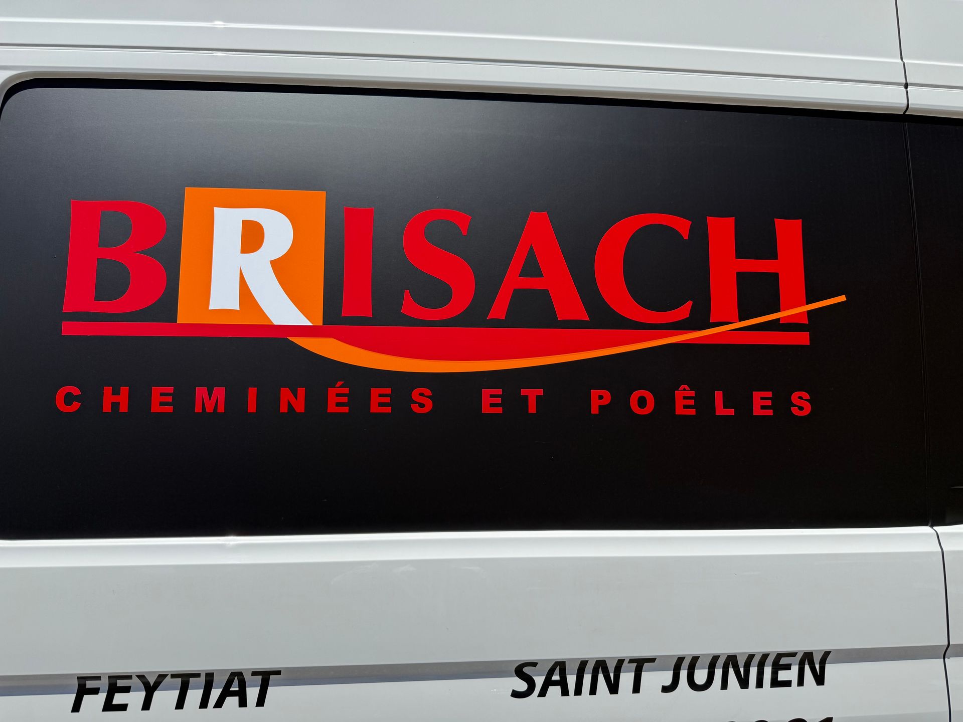 Logo Brisach sur la vitre d’un véhicule.