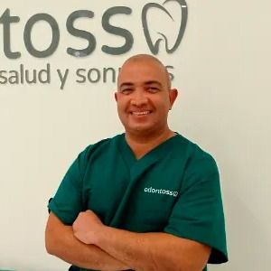 Un hombre con un uniforme verde está parado frente a un cartel que dice 