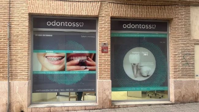 Un consultorio dental con una foto de los dientes de una mujer en la ventana.