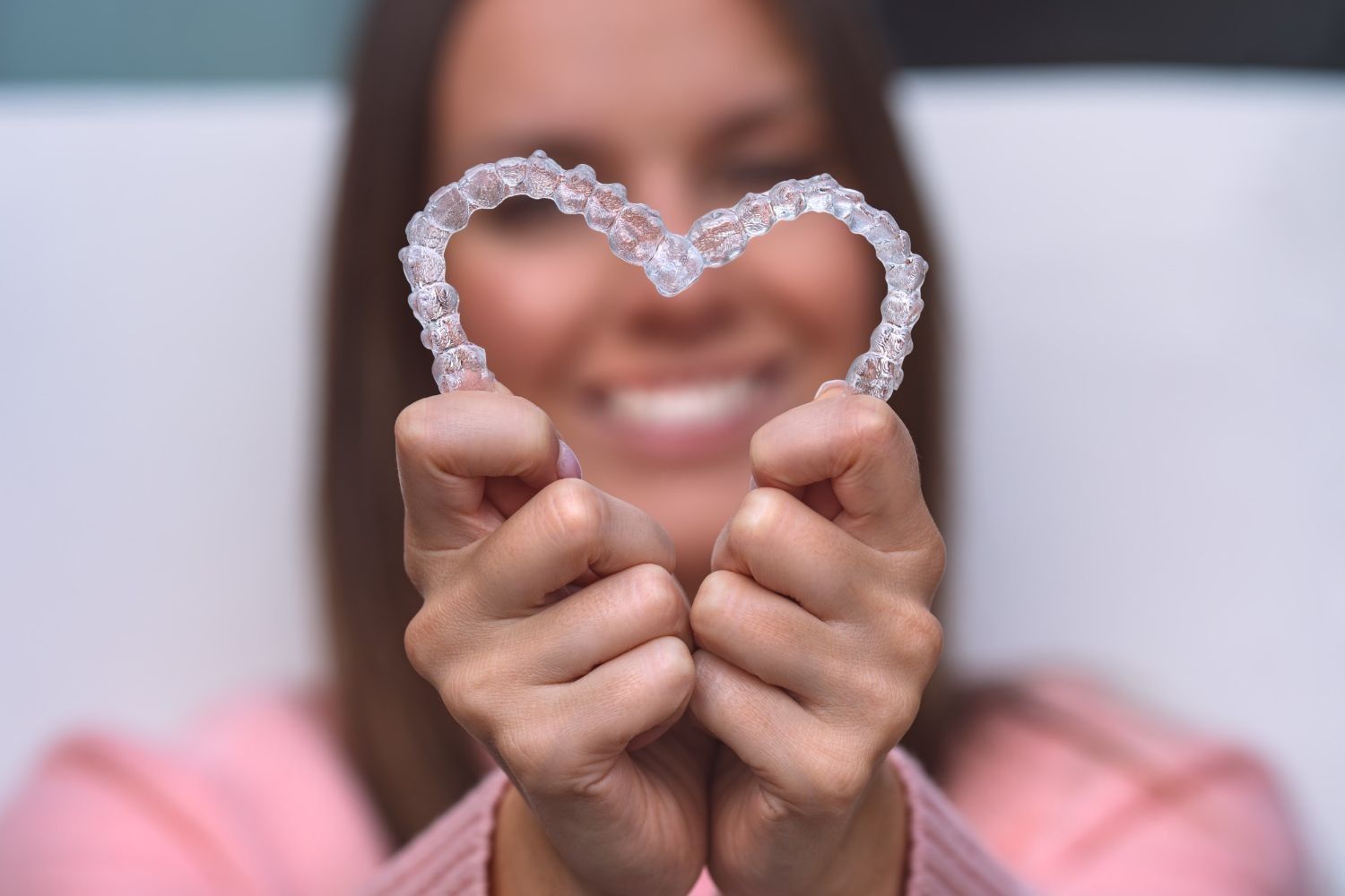 Una mujer sostiene en sus manos un retenedor con forma de corazón.