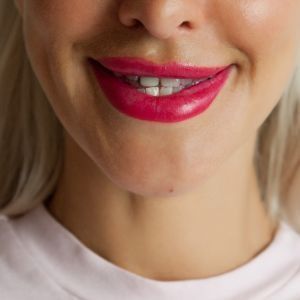 Un primer plano de la boca de una mujer con lápiz labial rojo.
