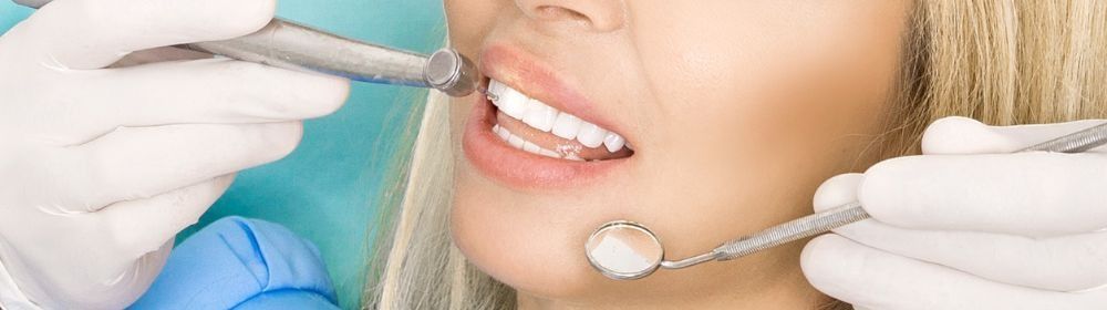 Una mujer está siendo examinada por un dentista.