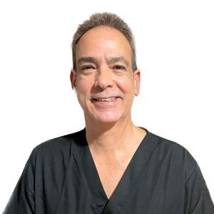 Un hombre con un uniforme negro sonríe para la cámara.
