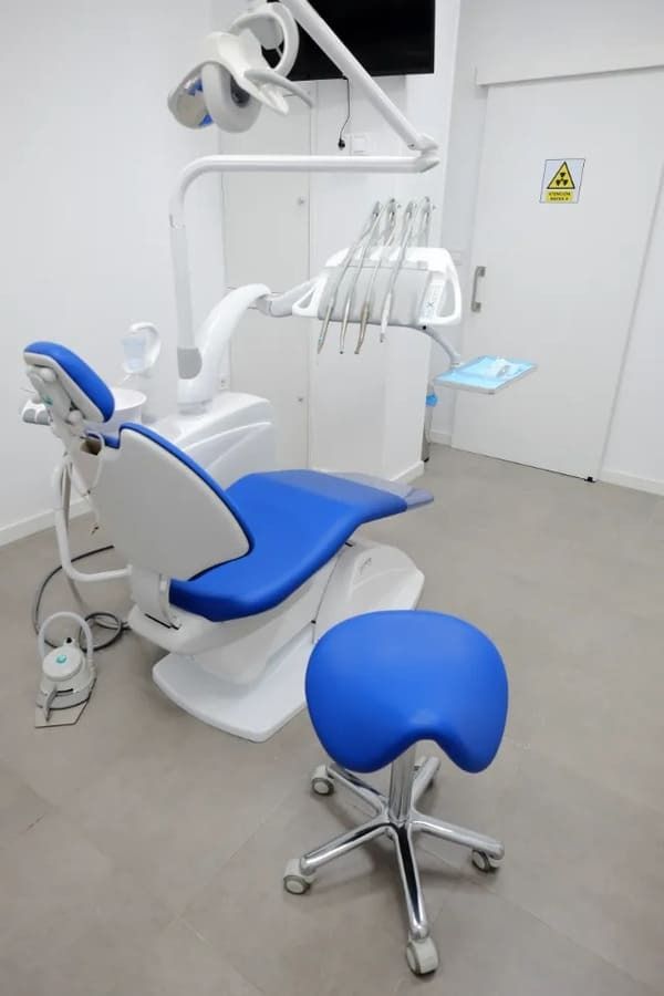 Un sillón dental azul y blanco en un consultorio dental.