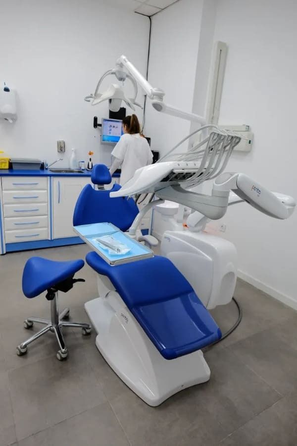 Un dentista está trabajando con un paciente en un consultorio dental.