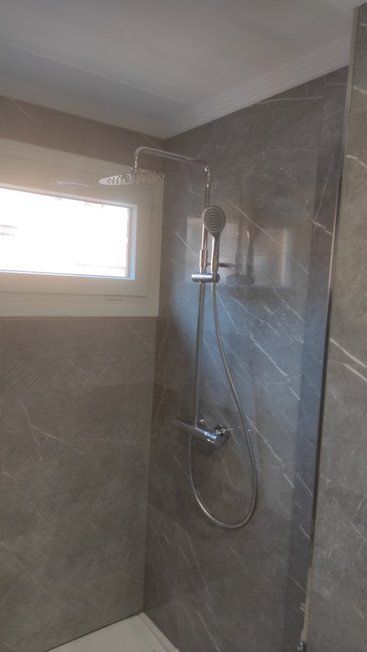 Un baño con ducha y ventana.