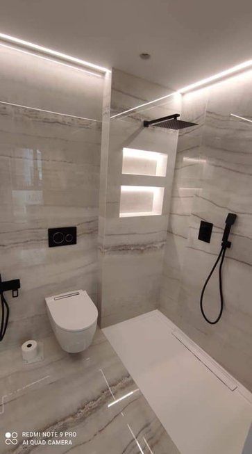 Un baño con inodoro, ducha y estanterías.