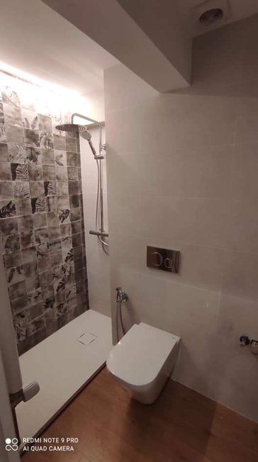 Un baño con inodoro, ducha y lavabo.