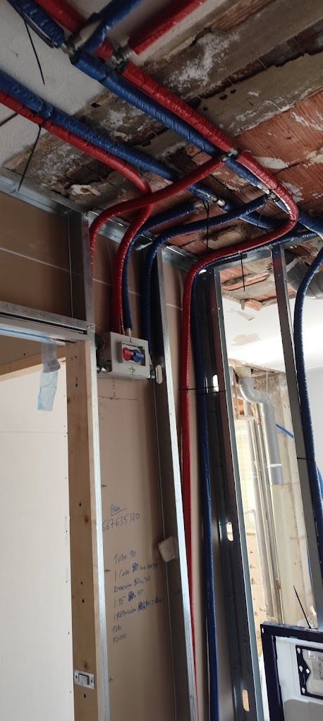 Una habitación con muchas tuberías colgando del techo.