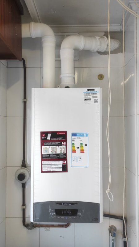 Una caldera blanca cuelga del techo de un baño.