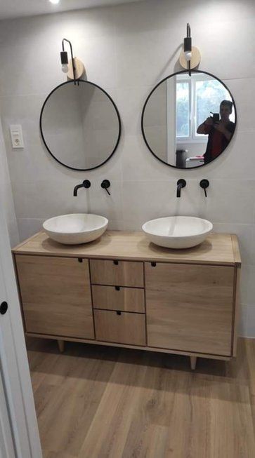 Un baño con dos lavabos y dos espejos.