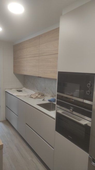 Una cocina con fregadero, microondas y frigorífico.